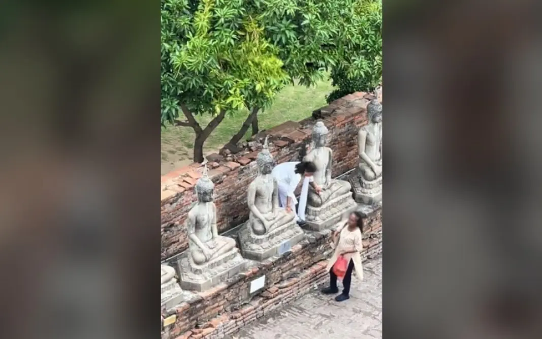 Kultureller Fehltritt: Indische Touristen klettern auf Buddha-Statue, um Mangos zu pflücken – Video