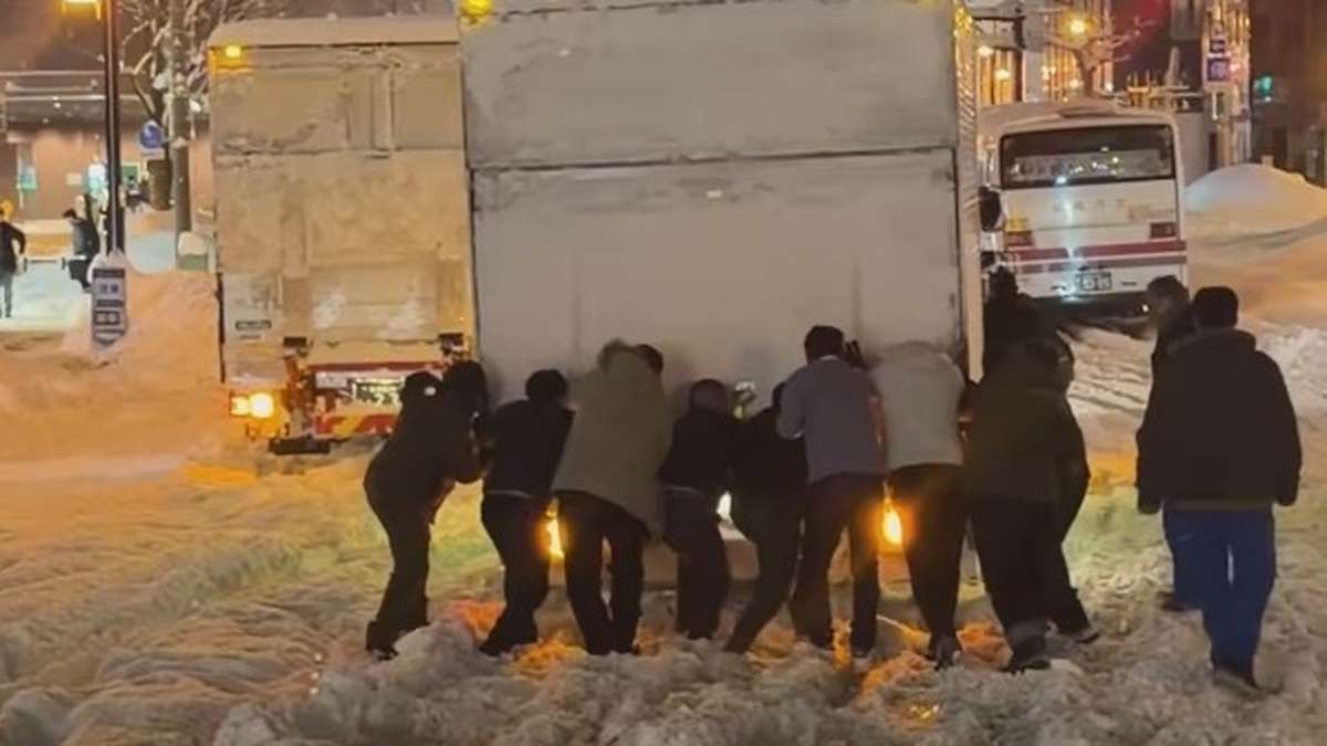 Thai-Reisegruppe unterstützt Fahrer nach Wintereinbruch