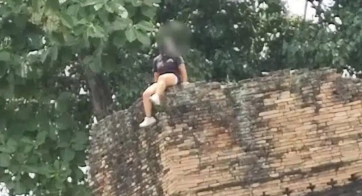 Touristin klettert auf Stadtmauer in Chiang Mai