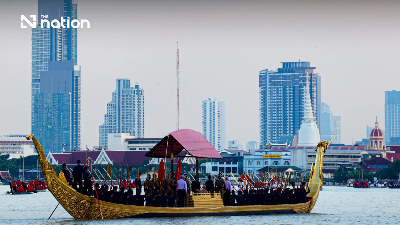 Goldene königliche Barke mit rotem Baldachin auf dem Chao Phraya vor Hochhäusern und einem weißen Chedi