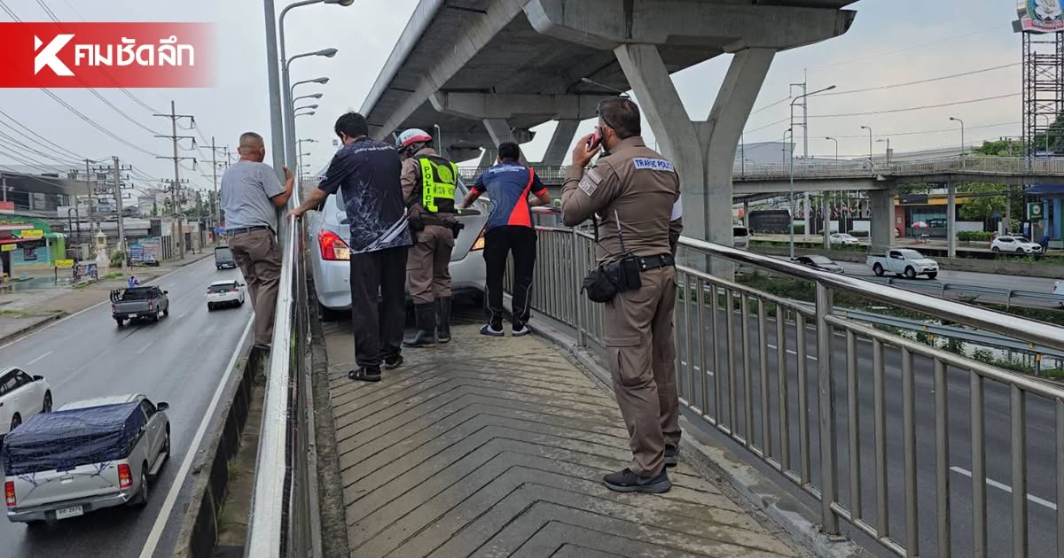 Polizisten und Helfer stehen auf der Rampe hinter dem festsitzenden weißen Sedan in Samut Sakhon