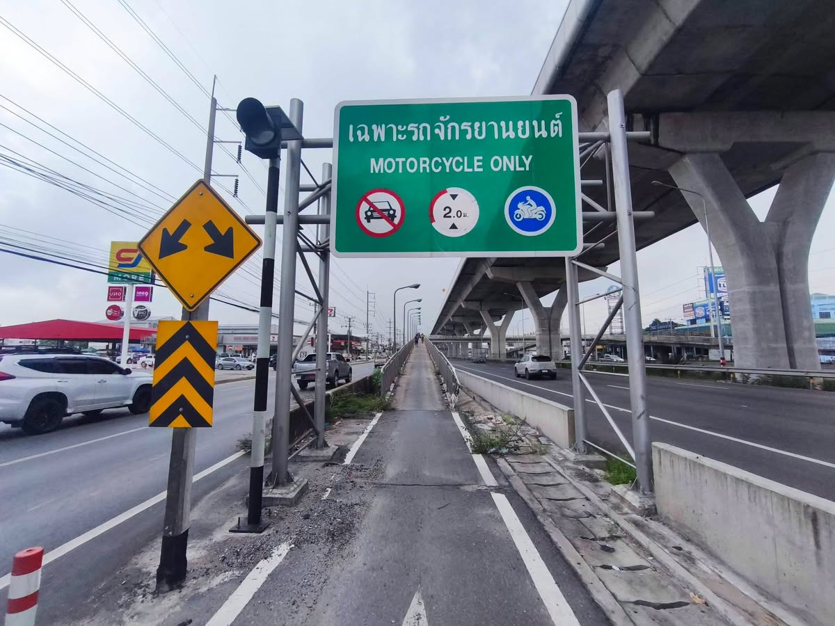 Grünes Schild „Nur Motorräder“ mit Auto-Verbotszeichen an der Auffahrt der Motorrad-Rampe an der Rama II in Samut Sakhon